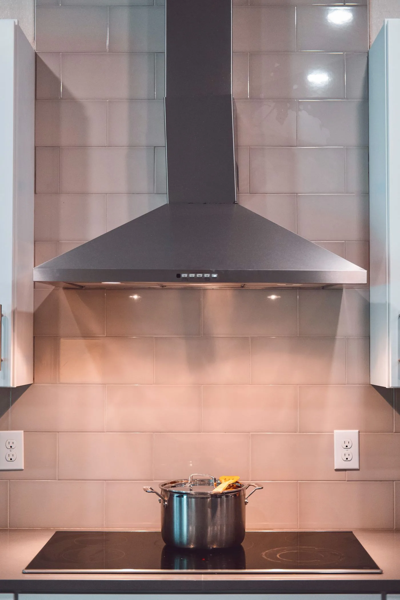 Cooking hob beneath a stainless steel extractor hood
