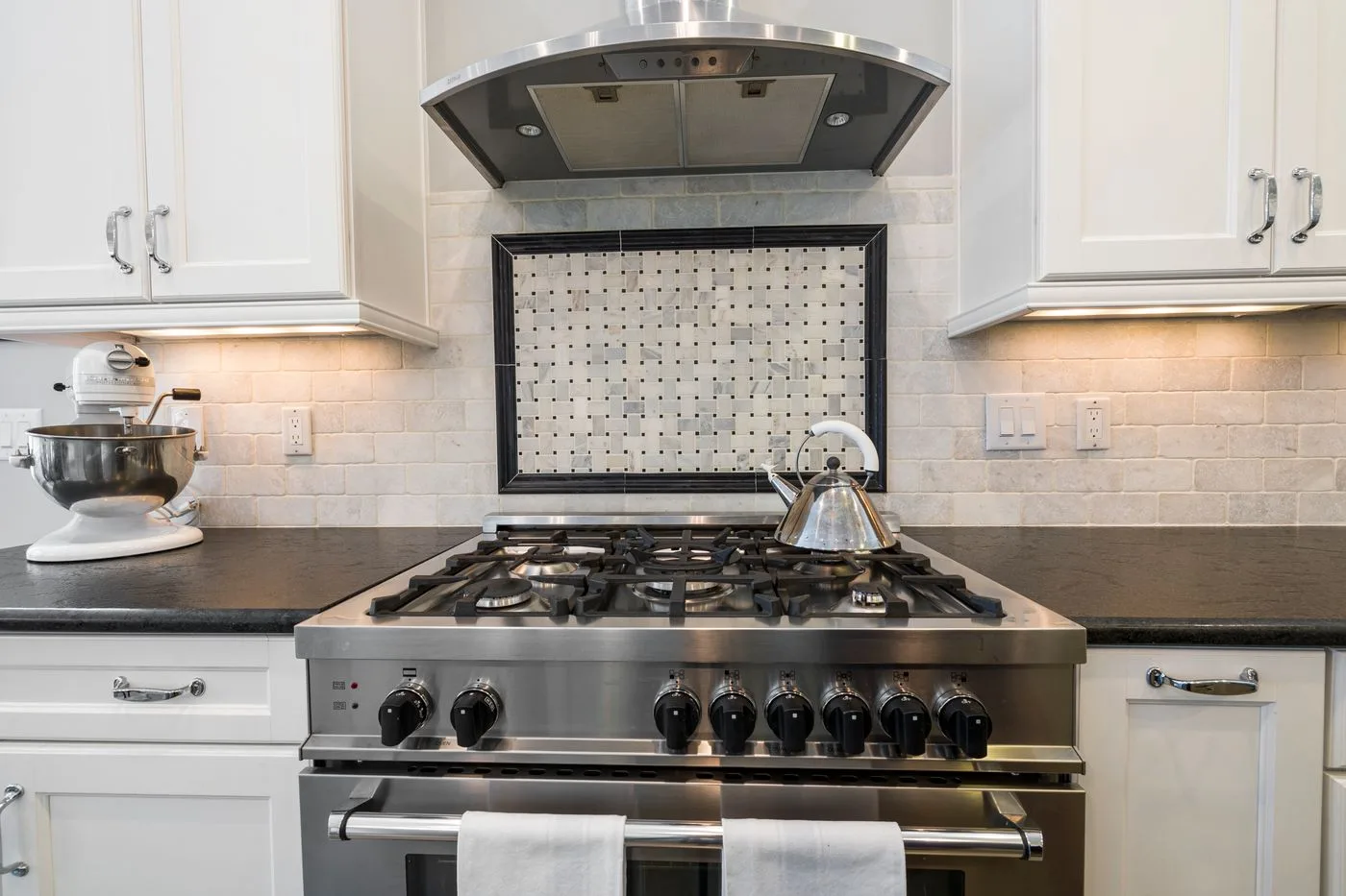 Stainless steel cooker and kettle in a fitted kitchen